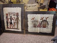 Both framed papyrus artworks side by side on carpet