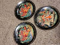 All three Palekh porcelain plates on carpet