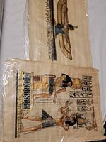 Two papyrus paintings in plastic sleeve showing Egyptian motifs