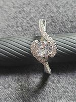Front view of silver ring with moissanite center and pave halo
