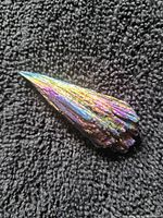 Top view of small iridescent kyanite fan on fabric