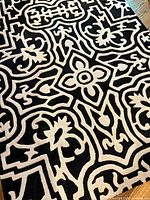 Full view of black and ivory floral wool area rug
