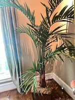 Full view of artificial palm tree showing height, leaves, trunk, planter