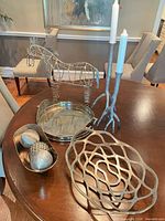 Group shot of entire lot on table showing horse, candlesticks, bowls, tray, spheres