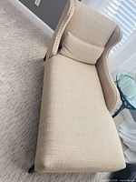 Full view of chaise lounge showing upholstery, pillow, and overall form