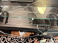 Glass riser shelf with attached dock and cabling visible