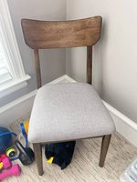 Front view of dining chair showcasing wood frame and upholstered seat