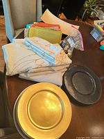 overview of gold charger, black charger, patterned and solid napkins, rectangular tray visible