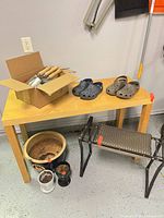 table with hand tools, clogs, bench, planters visible