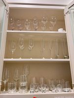 Cabinet shelves showing stemware, tumblers and shot glasses