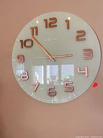 Front view showing full clock face, numerals, hands, brand logo