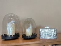 Two glass cloches with candles and hammered metal box