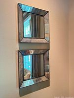 Pair of square mirrors mounted vertically on wall
