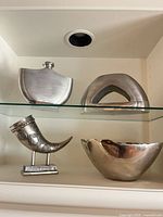 All four decorative metal pieces on shelf