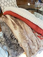 Stack of blankets in background; humidor not visible