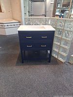 Front view of navy vanity with quartz top and sink