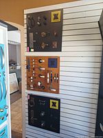 Three vertical slatwall-mounted display boards showing all hardware samples