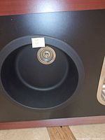 Front view of round anthracite sink mounted in display cabinet