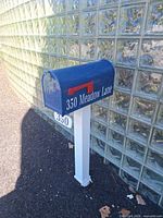 Mailbox full view showing blue box, white post, red flag