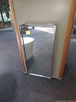 Front view of mirrored medicine cabinet mounted on display wall