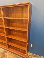 Front view of tall cherry veneer bookcase with shelves