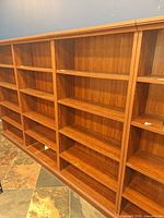 Full view of multi-section bookcase showing cherry finish and shelving