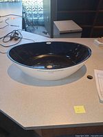 Side profile showing black interior and white exterior of vessel sink on countertop