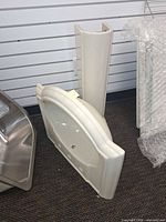 front view of pedestal and basin leaning against wall