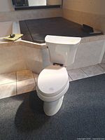 Front view of white Kohler elongated toilet on showroom floor