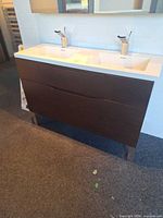 Front view of espresso vanity with white double sink and chrome faucets