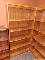 Front view of medium brown veneer bookcase showing all shelves