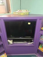Vizio E321VA 32 inch TV seated in shelving with Apex AD-1225 DVD player beneath