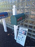 Front angled view showing full green mailbox, white post, vinyl address lettering