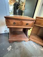 Wider nightstand showing drawer fronts, open shelf and base