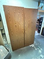 Front view of two-door oak-grain armoire cabinet