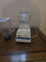 Blender base with chopper bowl attached, blending jar beside