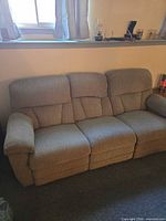 Three-seat tan reclining sofa front view
