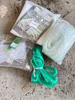 All items grouped: sealed mesh netting package, cable ties pack, green netting bundle, translucent mesh roll