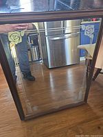 front view of rectangular mirror showing etched floral design and wood frame