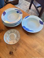 Stacked porcelain bowls and one glass plate on table