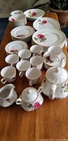 All plates, bowls, cups, teapot, creamer and sugar bowl arranged on table