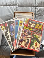 Box filled with bagged and boarded comics, top issues visible