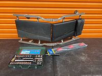 Creeper seat frame with cushions, socket set case open showing contents, sealed punch set