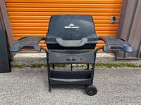 Front view of closed Fiesta propane grill showing side shelves and wheels