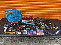 Overall view of lot on table showing all tools, lights, gauges, crate