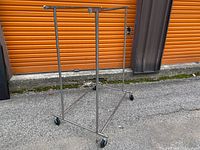 Full view of rolling garment rack showing frame and casters
