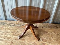 Full view of round accent table showing top and pedestal legs