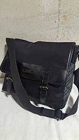 Front view showing flap, buckles, strap and Burberry Black Label plate