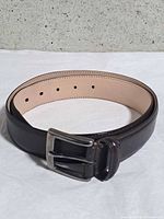 Coiled belt showing buckle, grain and lining