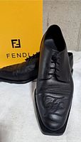 Front angled view showing left and right shoes with FF embroidery and Fendi box